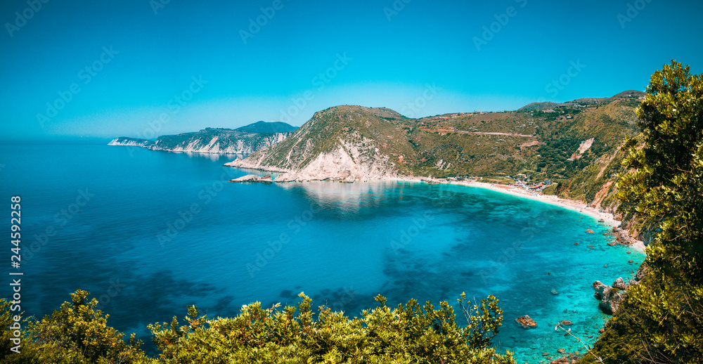 Panorama View to Petani beach with transparent and crystal clear blue mediterranean sea water in picturesque bay, Kefalonia island, Greece