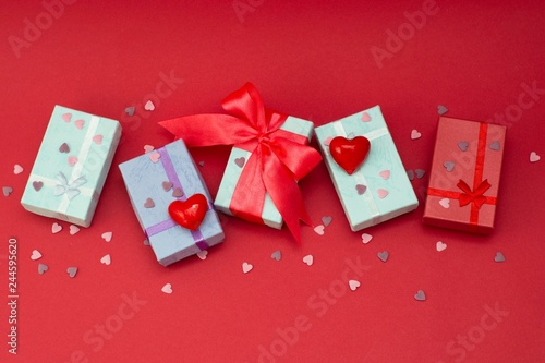 Many colorful gift boxes on red background. Valentine's day, mother's Day, birthday or party concept. Hearts decorations. Copy space. photo