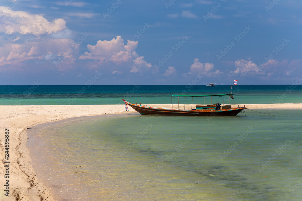 Traditional thai long boat moored at a beach Traditional thai long boat moored at a beach