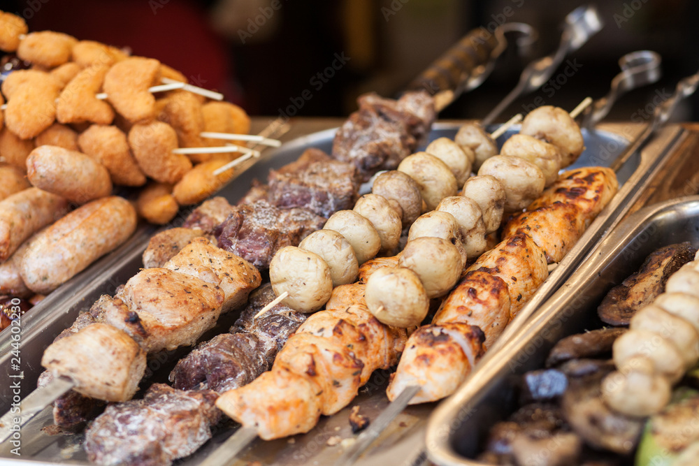 Different types of delicious meat and mushrooms on skewers. Outdoor Cuisine Culinary Buffet.