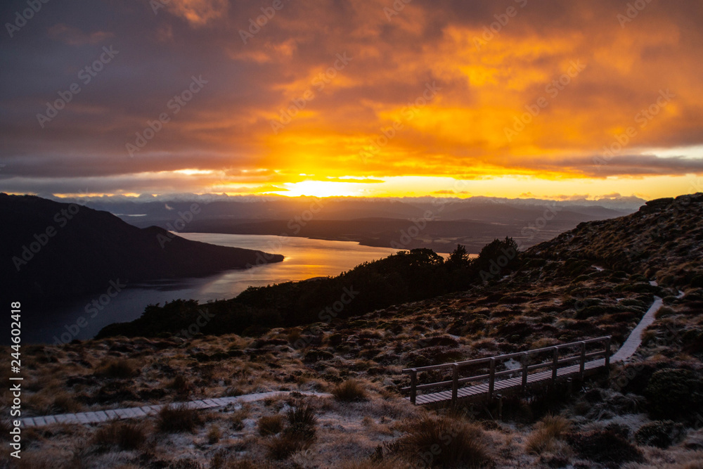 Amazing sunrise over the mountains and fiord in Fiordland national Park, South Island, New Zealand. Mountain scenery, beautiful outdoor background. Snow on the peaks. Kepler track, Luxmore Hut NZ