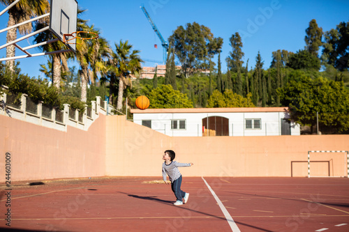 Child with his ball on the basketball court
