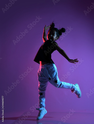 Obraz na płótnie Asian kid girl in shirt and pants with stars dances like a disco star w salonie