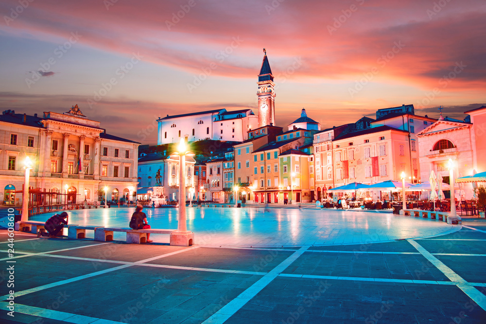 Beautiful city scenery in the central square with the old clock tower in Porec, the tourist center of Croatia, in the light of lanterns.