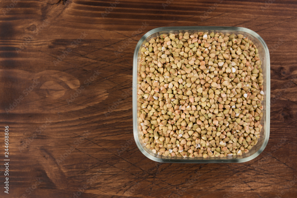 Natural fresh green buckwheat in glass bowl on wooden background. Top view Natural fresh green buckwheat in glass bowl on wooden background. Top view