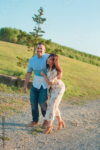 Young happy engaged couple walking outside at sunset © Mary Perry