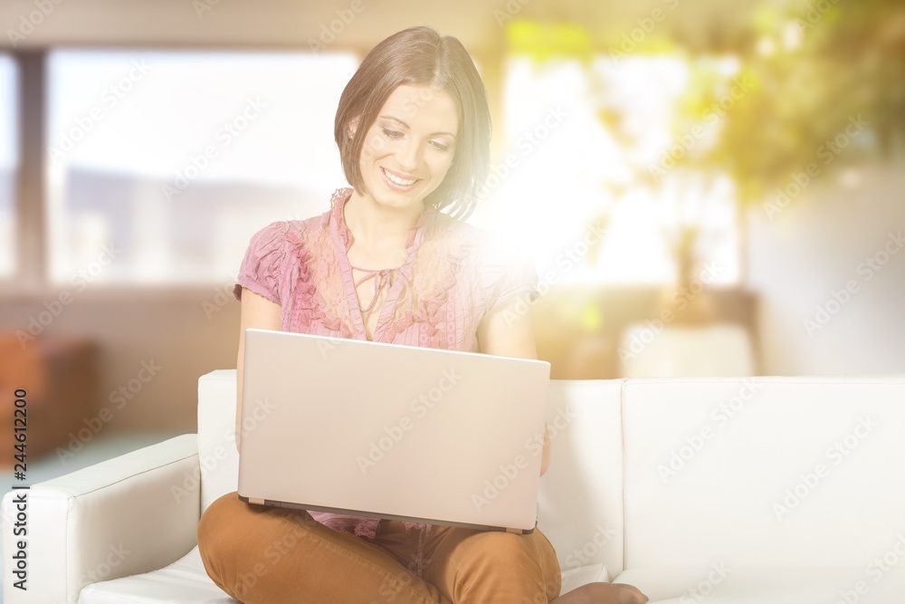 Woman using laptop on the sofa at home Woman using laptop on the sofa at home