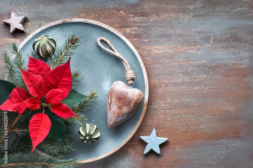 Flat lay with fir twigs, poincettia and Xmas decorations on textured background with copy-space photo