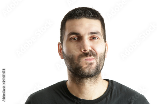 Studio shot of a young bearded man making a facial expression