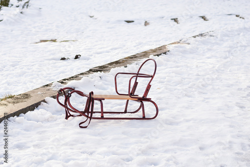 Children empty coaster is standing on snow in park in winter sunny day. Time for fun and happiness. Family time passing. photo