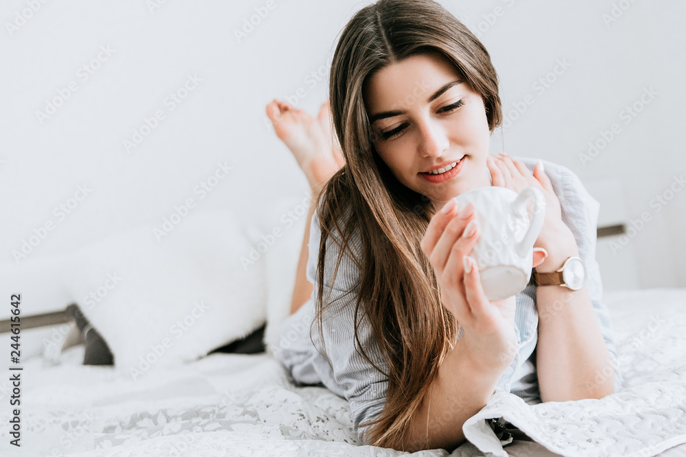 Young smiling woman drink a coffee in her bedroom. Happy morning. Young smiling woman drink a coffee in her bedroom. Happy morning.