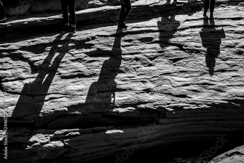 Quadro su tela Shadows of four young people against the Sun over huge sea cliff at the Love Can