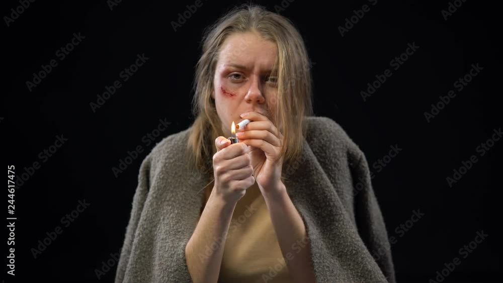 Depressed woman with wounded cheek trying to smoke and crying desperately Depressed woman with wounded cheek trying to smoke and crying desperately
