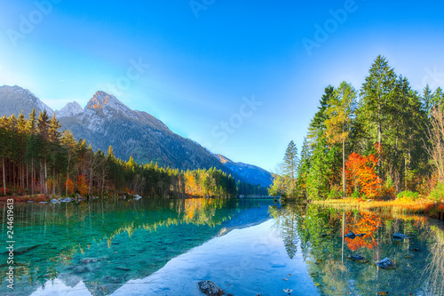 Beautiful autumn sunrise scene with trees near turquoise water of Hintersee lake