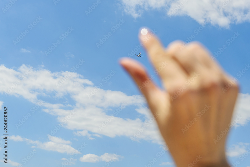 female hand holding an airplane flying in the sky female hand holding an airplane flying in the sky