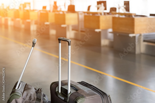 Foto Luggage suitcases at airport terminal with empty check-in desk