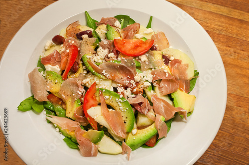 Mixed summer salad with avocado, ham and tomato