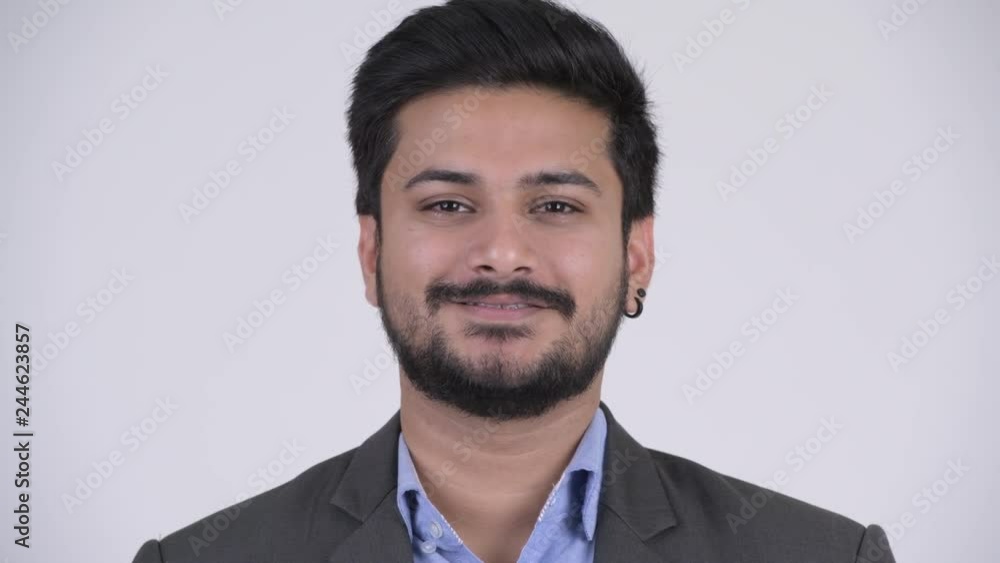 Portrait of young happy bearded Indian businessman smiling Portrait of young happy bearded Indian businessman smiling