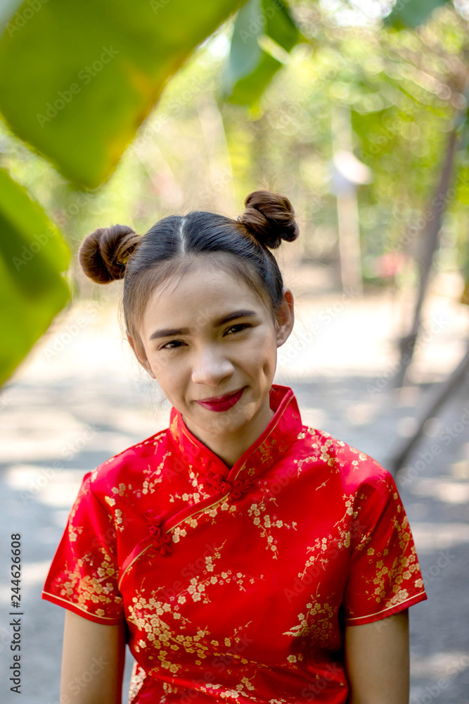 Asian women Wearing Chinese red dress Women wearing red dresses Do Chinese hairstyles Red lip smile A woman wearing a Chinese dress,Stand in the garden There is a banana tree And bamboo in back. Asian women Wearing Chinese red dress Women wearing red dresses Do Chinese hairstyles Red lip smile A woman wearing a Chinese dress,Stand in the garden There is a banana tree And bamboo in back.