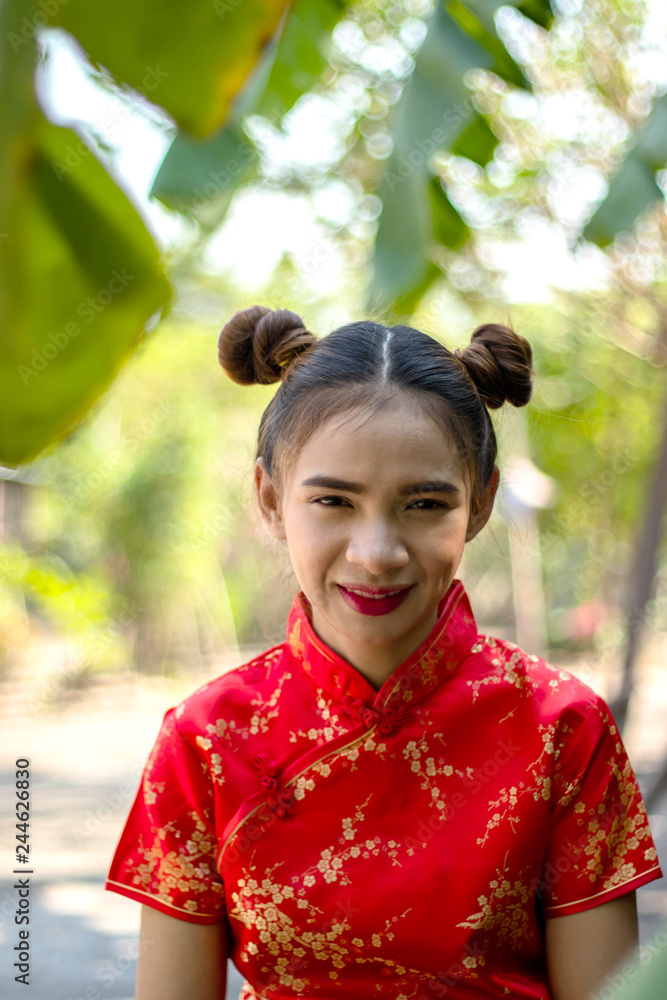 Asian women Wearing Chinese red dress Women wearing red dresses Do Chinese hairstyles Red lip smile A woman wearing a Chinese dress,Stand in the garden There is a banana tree And bamboo in back. Asian women Wearing Chinese red dress Women wearing red dresses Do Chinese hairstyles Red lip smile A woman wearing a Chinese dress,Stand in the garden There is a banana tree And bamboo in back.