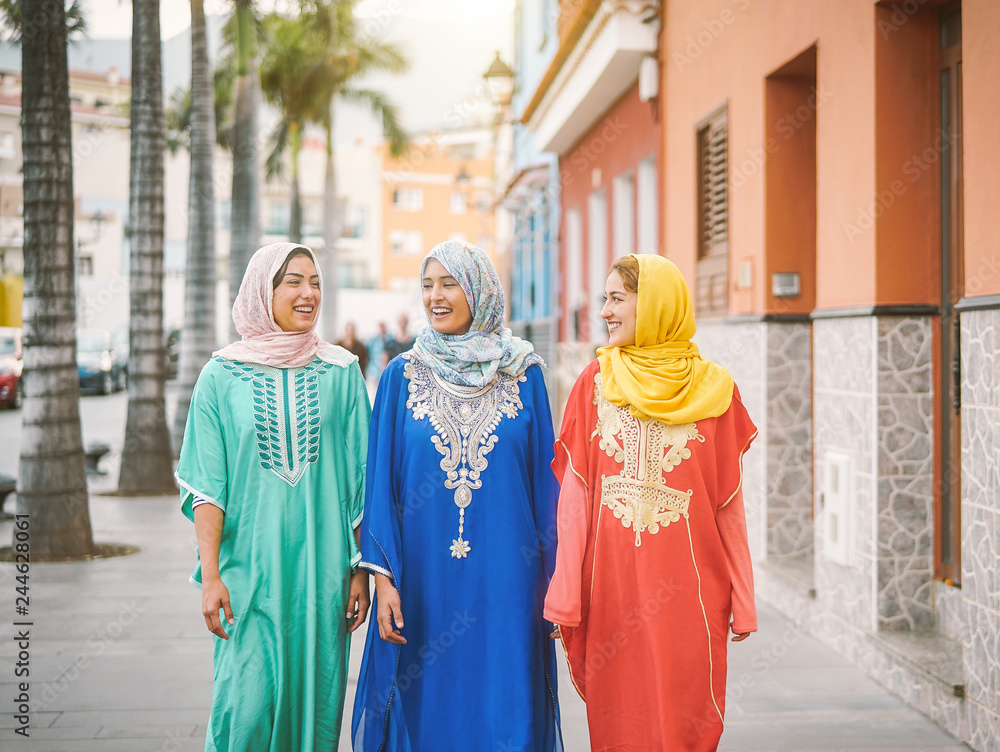 Happy muslim women walking in the city center - Arabian teen girls having fun spending time together outdoor - concept of people, culure and religion Happy muslim women walking in the city center - Arabian teen girls having fun spending time together outdoor - concept of people, culure and religion