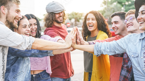 Group of diverse friends stacking hands outdoor - Happy young people having fun joining and celebrating together - Millennials, friendship, empowering, partnership and youth lifestyle concept