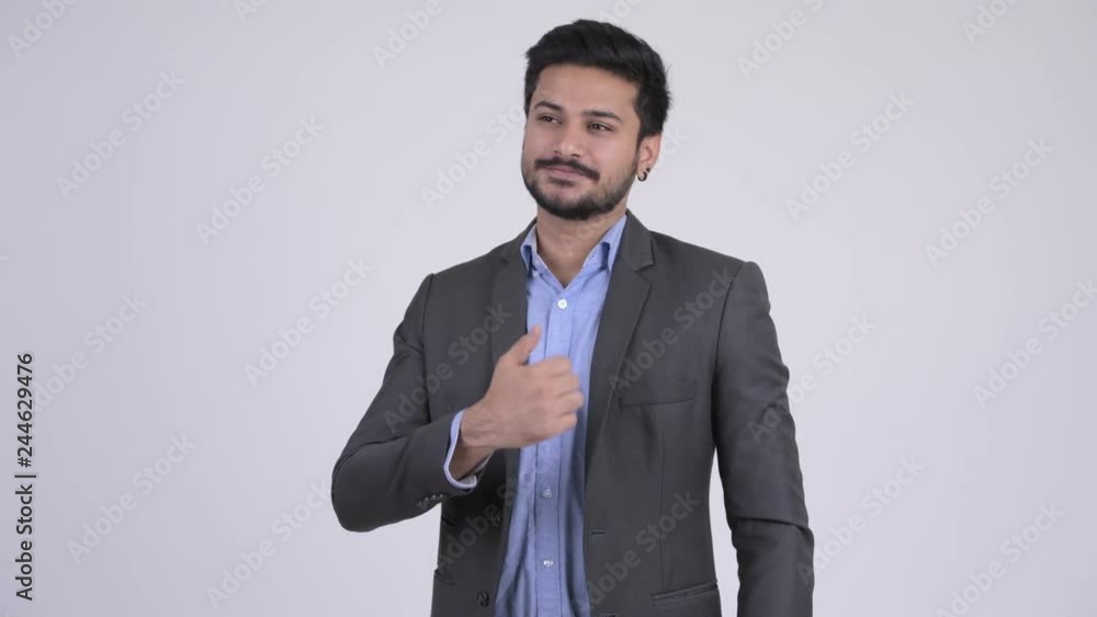 Young happy bearded Indian businessman giving thumbs up Young happy bearded Indian businessman giving thumbs up