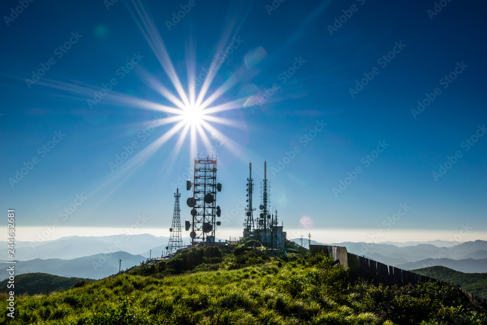 Obraz premium The sun is rising on the broadcast relay tower of Hambaeksan Mountain.
