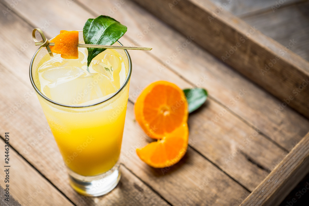 Fototapeta premium Fresh cocktail with mandarines on the rustic background. Selective focus. Shallow depth of field.