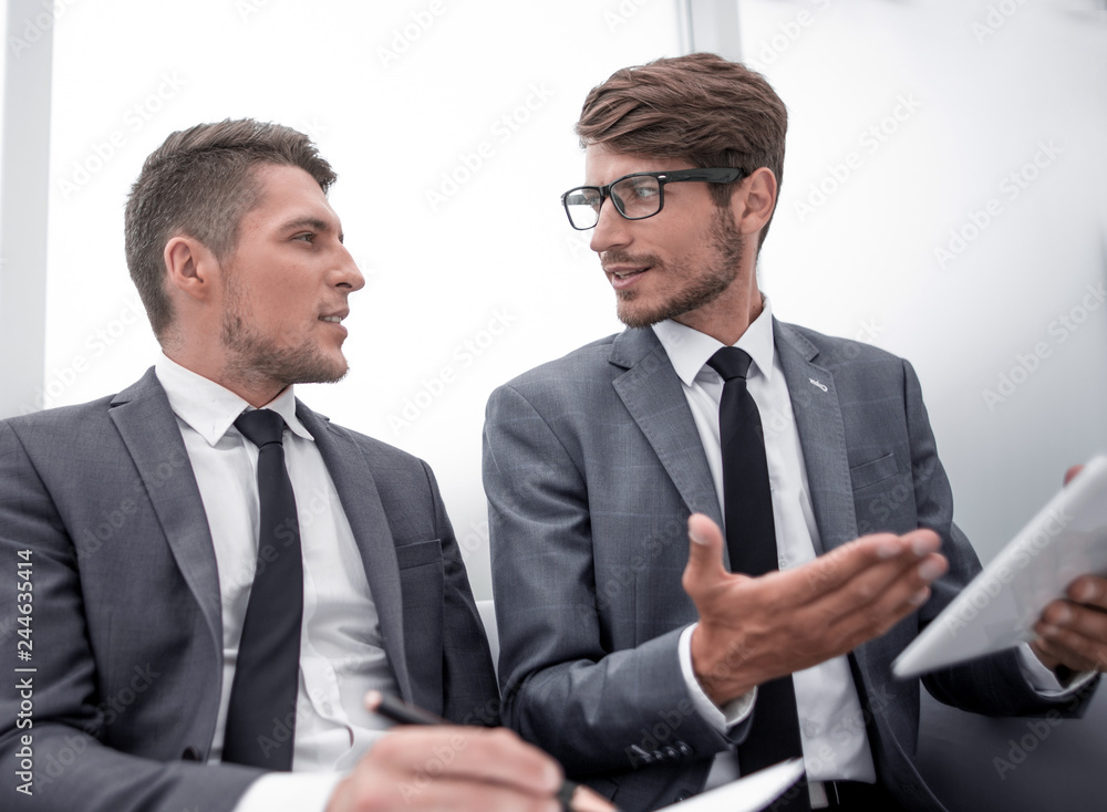 men are sitting in the office and using a tablet men are sitting in the office and using a tablet
