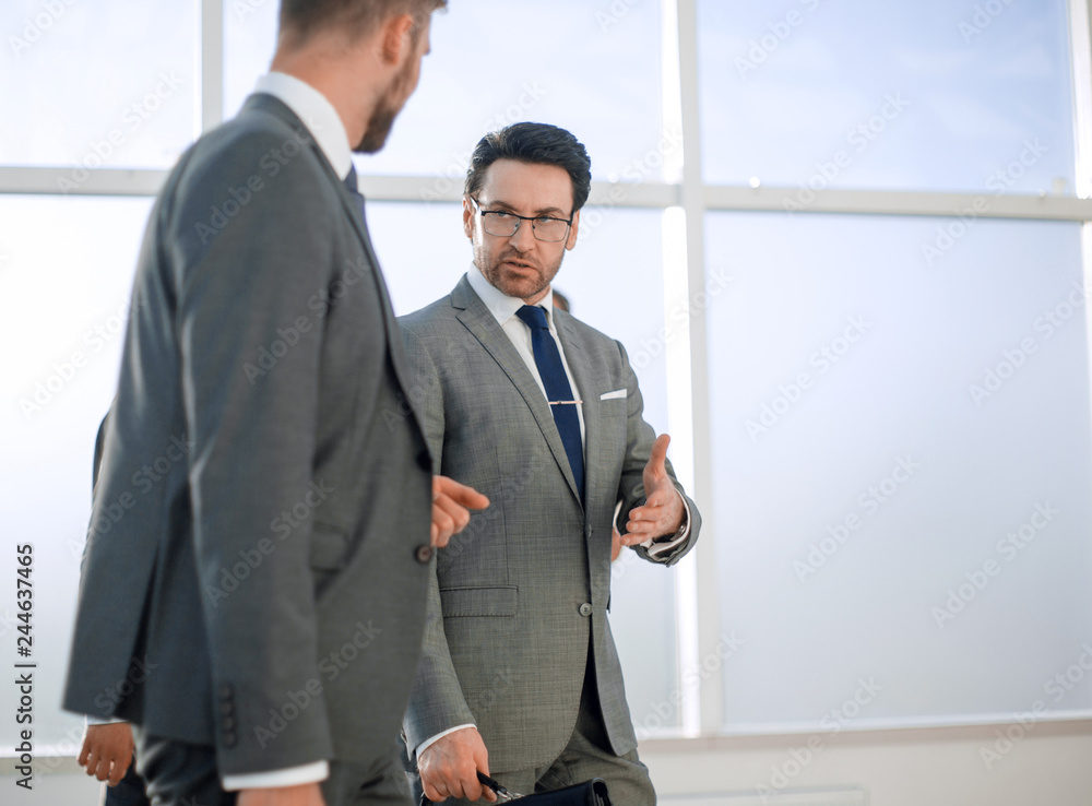 Two businesspeople walking in corridor talking