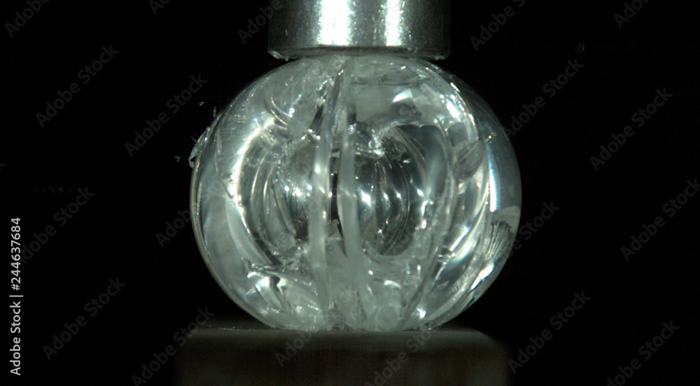 Glass Sphere being smashed to pieces by hydraulic press, shattering, moment of impact. Picture 1 Glass Sphere being smashed to pieces by hydraulic press, shattering, moment of impact. Picture 1