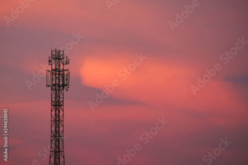 Silhouette top of radio antenna on the red dusk sky