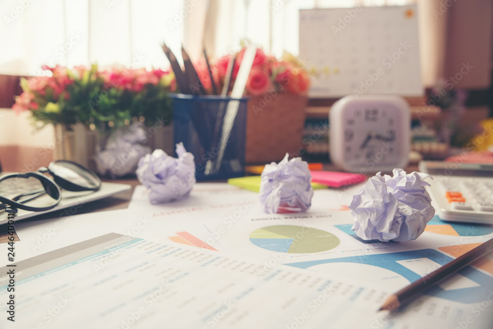 Business computer office desk with desktop laptop,crumpled paper,glasses,calculator,clock and annual,summary report,document and paper,working space at home.Business executive office table concept.