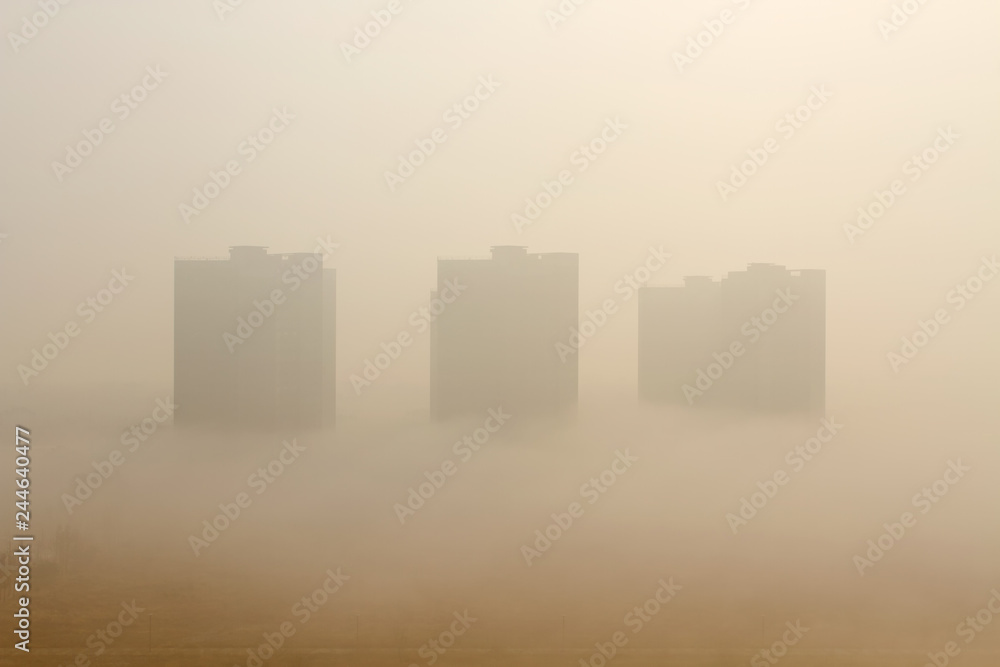 Environmental pollution concepts. Foggy buildings covered with ultrafine particles and smog.