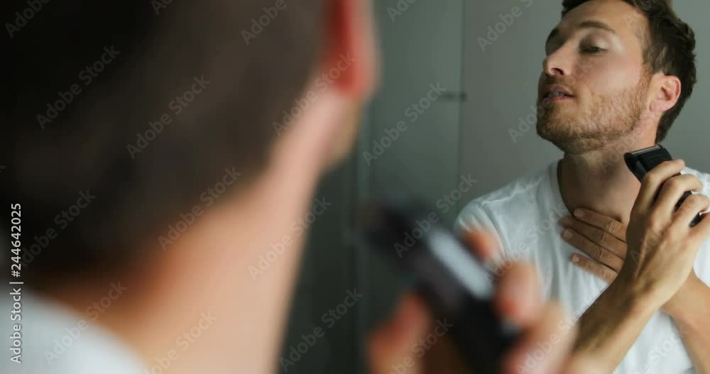 Man shaving beard using electric shaver trimmer. Male beauty grooming