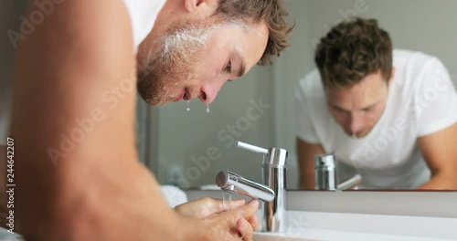 Man washing face rinsing soap from skin in sink under running cold water from faucet, Morning skincare routine. Male beauty skin care facial wash. Mask treatment.