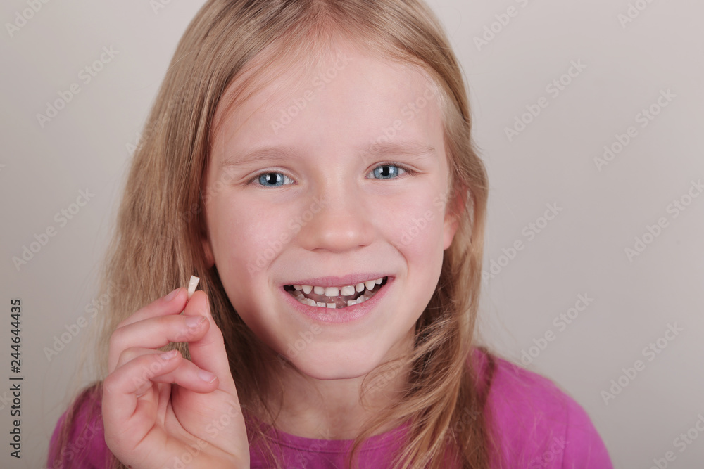 Young girl lost her first bottom front milk teeth. Childhood healthcare concept. Young girl lost her first bottom front milk teeth. Childhood healthcare concept.