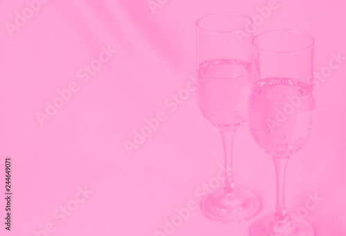 two glasses of champagne on background of fabric. pink toned