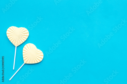 Fototapeta Naklejka Na Ścianę i Meble -  Heart-shaped lollipop for Valentine's day on blue background top view copy space