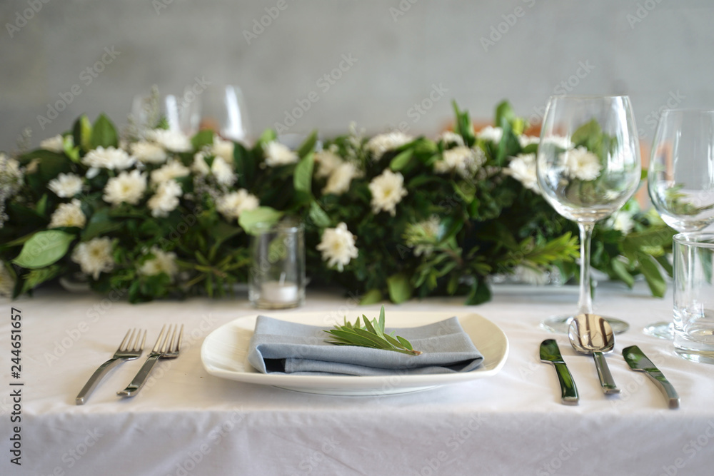 Dining set on the white table sheet with white bouquet flower background Dining set on the white table sheet with white bouquet flower background