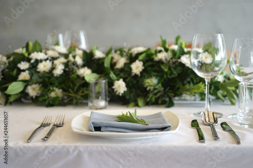 Dining set on the white table sheet with white bouquet flower background