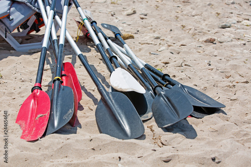 boat oars lie on the sand on the beach by the sea photo