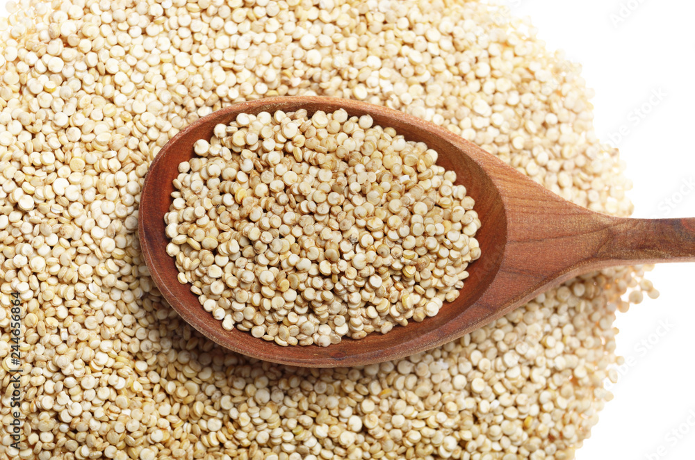 Raw organic superfood gluten free quinoa seeds in wooden spoon closeup on white background Raw organic superfood gluten free quinoa seeds in wooden spoon closeup on white background