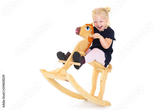 Girl swinging on a wooden horse.