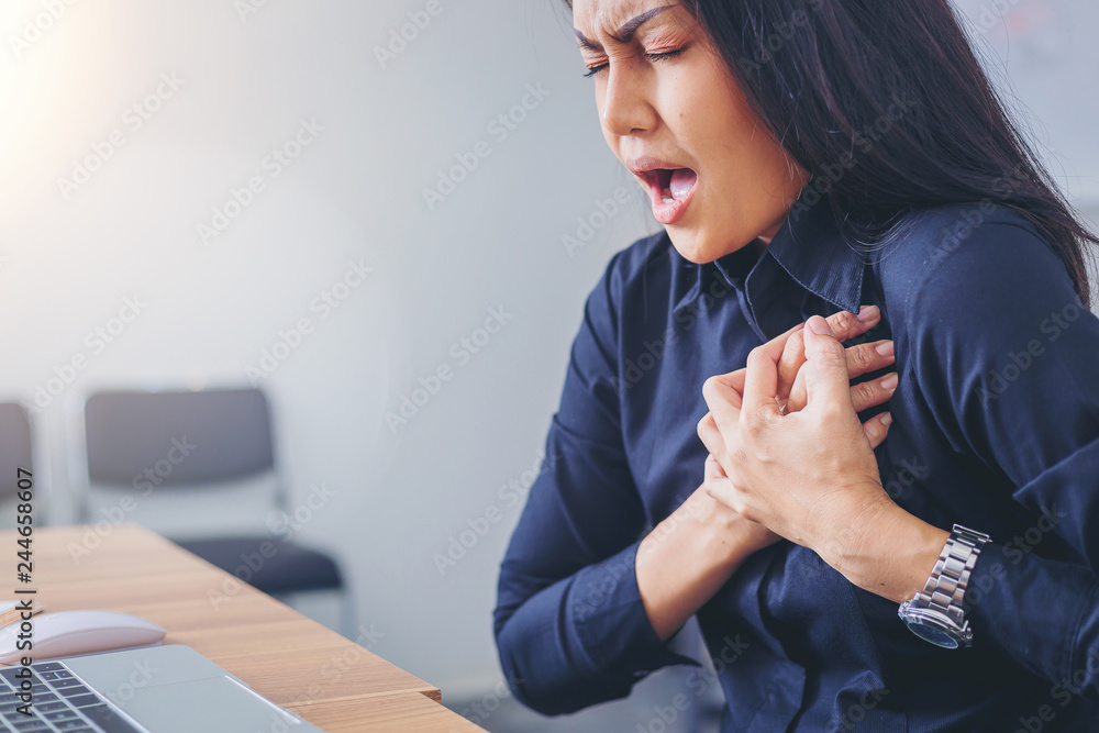 Working woman face suffering and holding breast because of heart infarction in office.