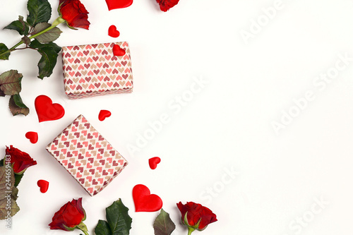 Border of gifts, rose flowers and decorative hearts on white background. Place for text, top down composition.