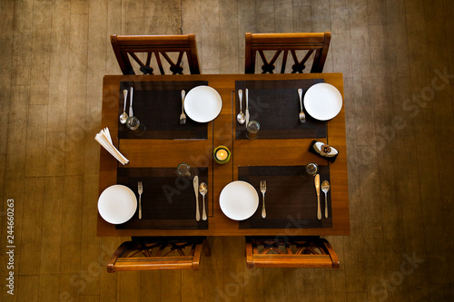 Photography Top view of the dining table in a wooden texture with white plates and spoons