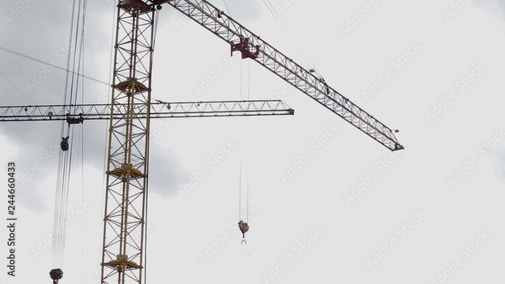 Construction crane lifts concrete plate on roof of house under construction Construction crane lifts concrete plate on roof of house under construction