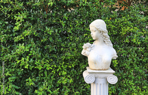 Woman statue in the garden with copy space. Wall leaf in nature park.